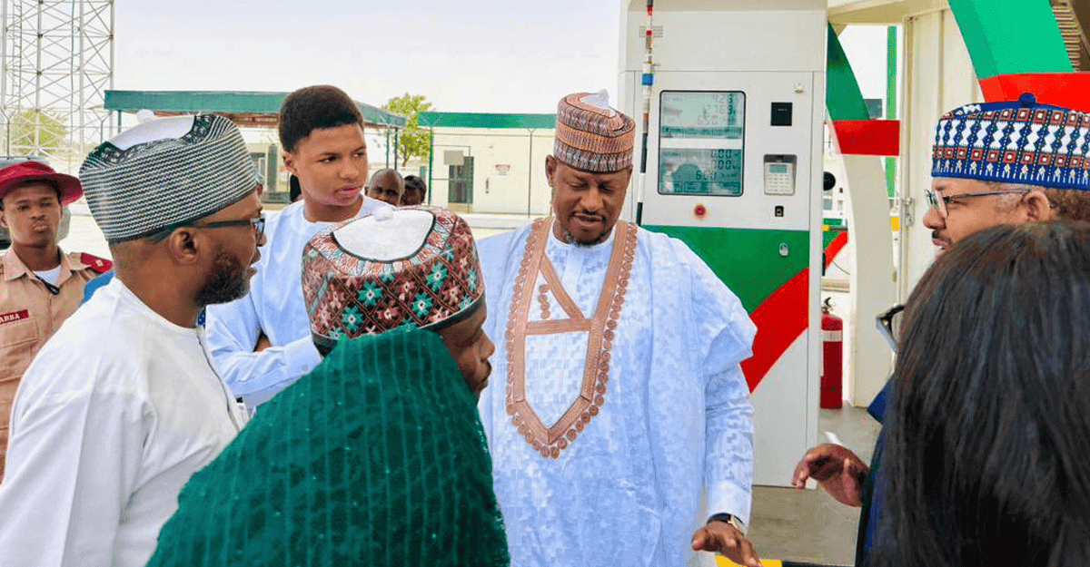 Villagers gathered around a CNG-powered bus in a rural Nigerian setting