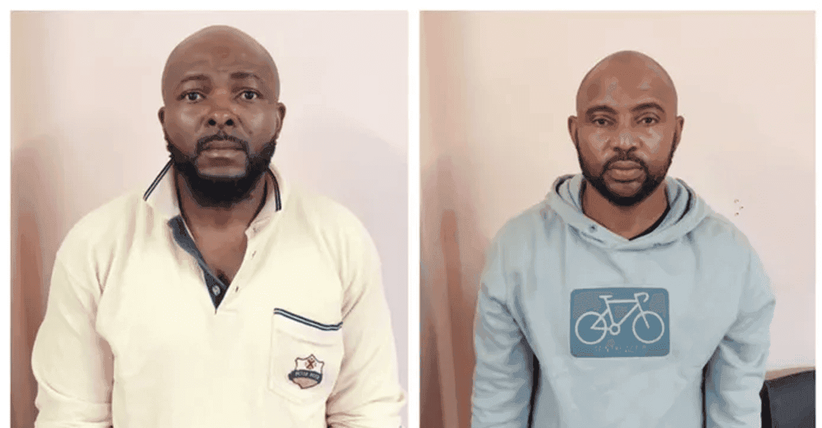 Two Nigerian men in handcuffs being led by South African police officers.